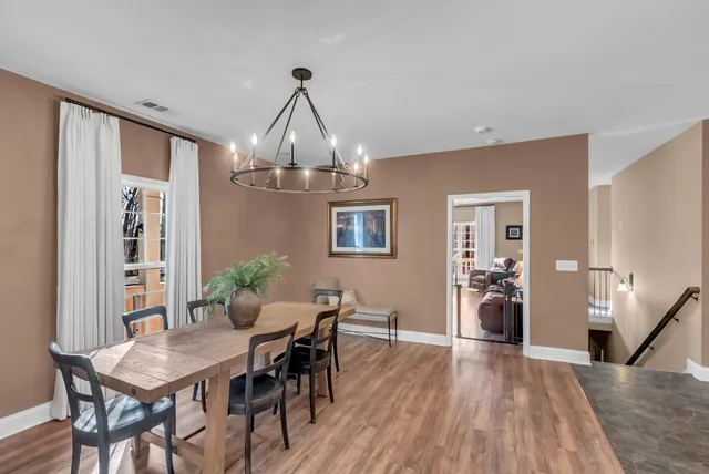 a kitchen with stainless steel appliances granite countertop a refrigerator a sink dishwasher a stove and white cabinets with wooden floor