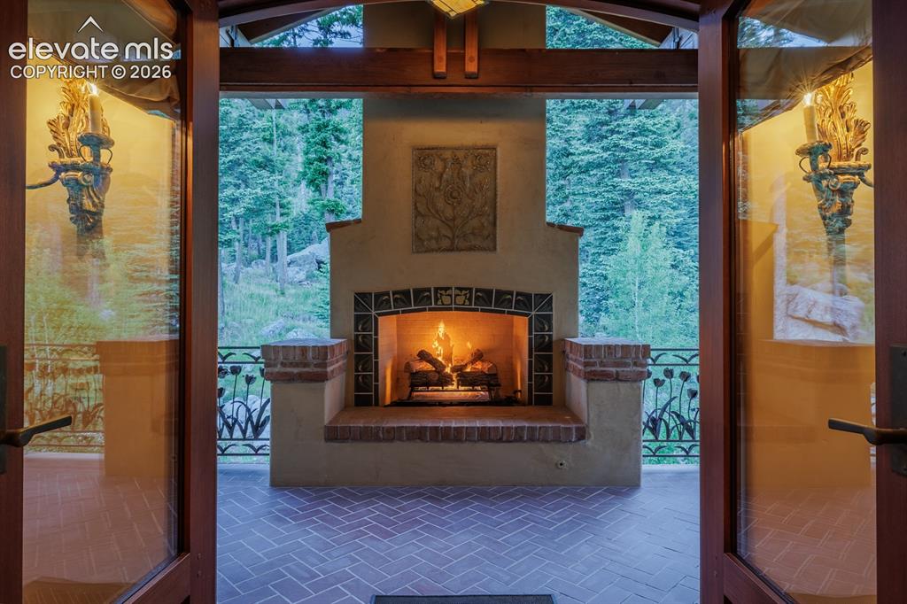 4530 Governors Point Colorado Springs, CO 80906 - Photo 12 of 49 Wonderful terrace through the primary suite doors with gas insert masonry fireplace and custom wrought iron "tulip" railing