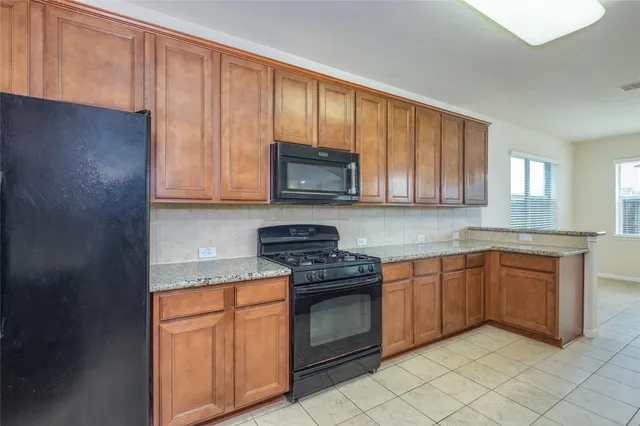 a kitchen with stainless steel appliances granite countertop a stove a sink dishwasher and a microwave oven on the blue kitchen countertops