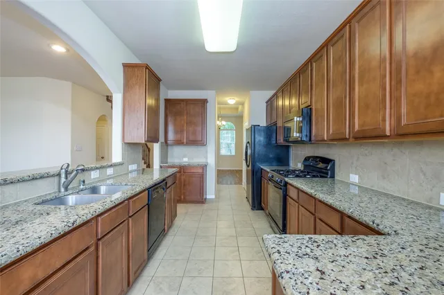a kitchen with stainless steel appliances granite countertop a sink stove and cabinets