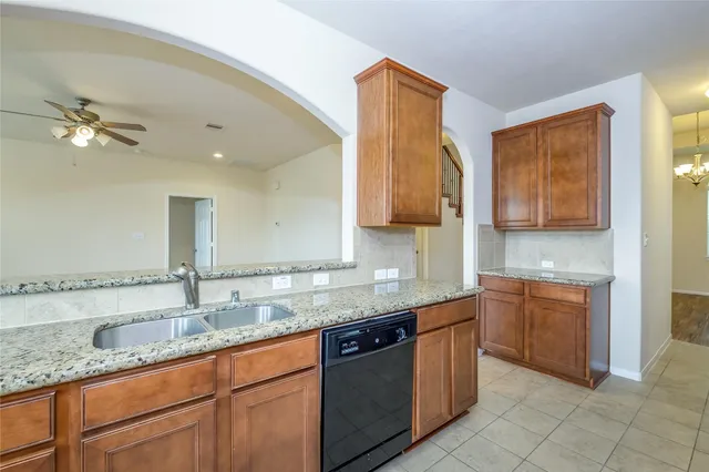 a kitchen with stainless steel appliances granite countertop a sink a stove and cabinets