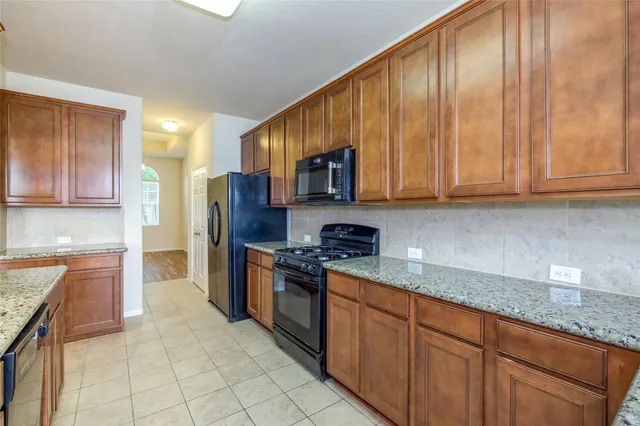 a kitchen with stainless steel appliances granite countertop a stove a sink dishwasher and a refrigerator