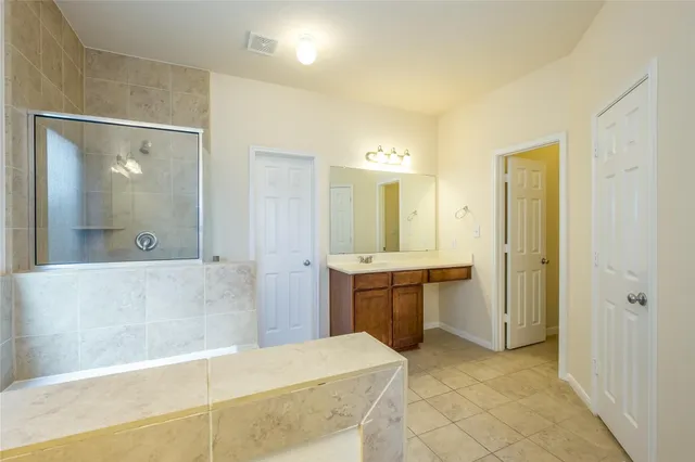 a spacious bathroom with a mirror sink and shower