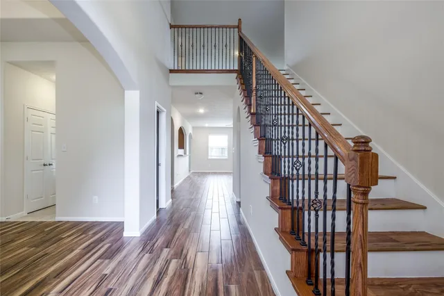 a view of a hallway with wooden floor and staircase