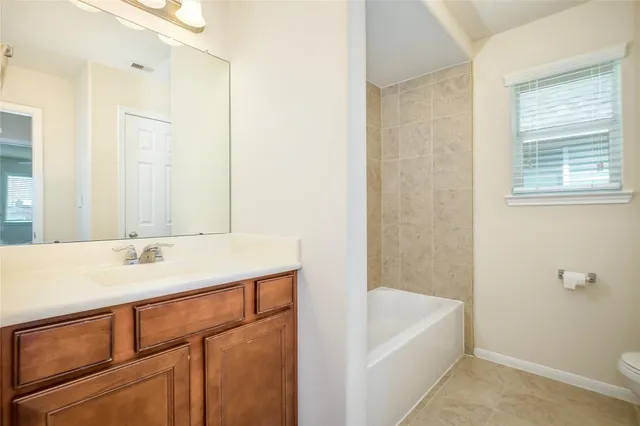 a bathroom with a tub sink and mirror
