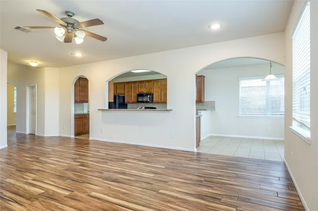 a view of a livingroom with a ceiling fan window and wooden floor