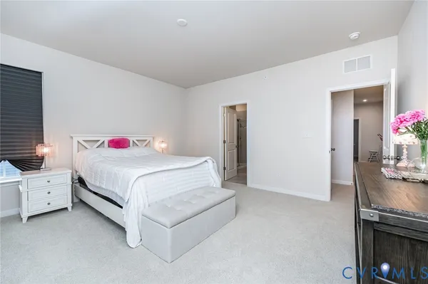 a spacious bedroom with a bed and a window