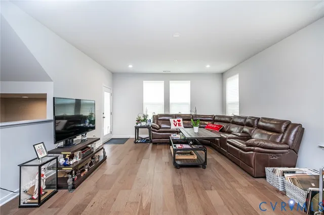 a kitchen with a stove a sink a kitchen island with chairs and wooden floor