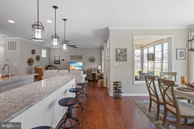 a view of a dining room and livingroom with furniture wooden floor a chandelier