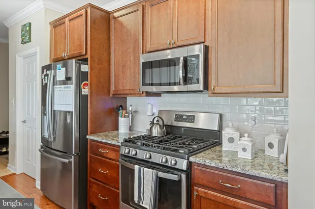 a kitchen with granite countertop a stove and a refrigerator