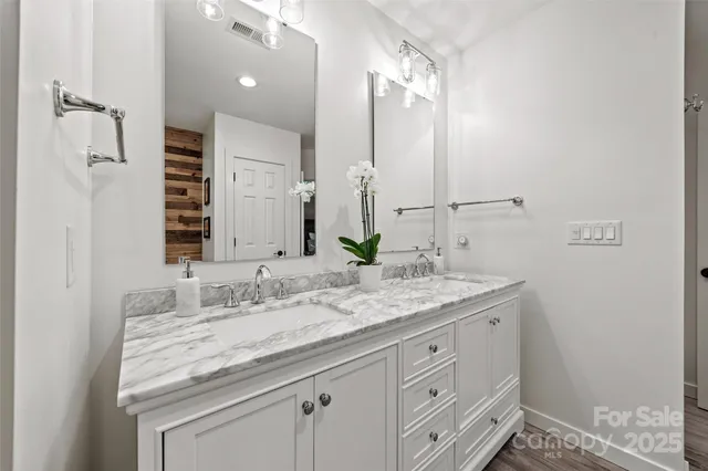a bathroom with a granite countertop sink double and mirror
