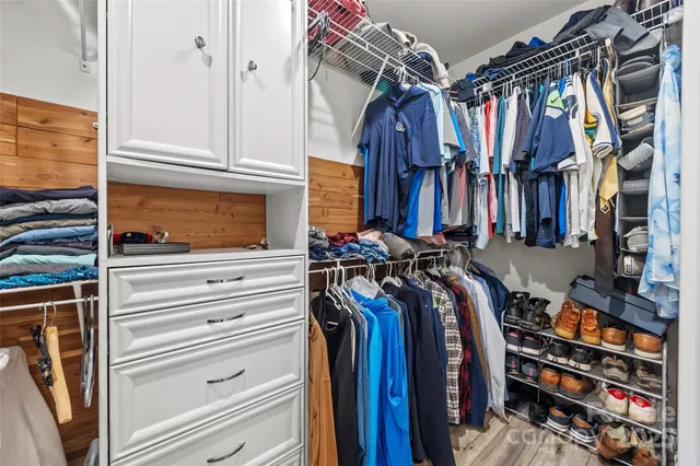 a view of walk in closet with clothes and shoes