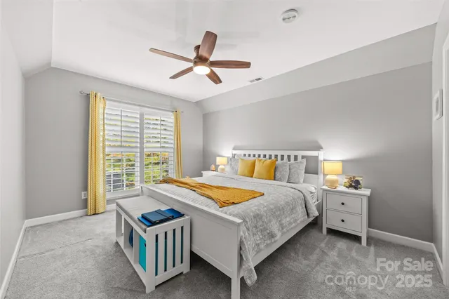 a bedroom with a bed a window and a chandelier