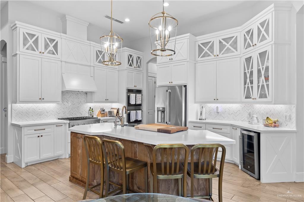 2504 Tulip Street Mission, TX 78574 - Photo 7 of 26 a kitchen with stainless steel appliances granite countertop a sink dishwasher a refrigerator and a dining table with wooden floor