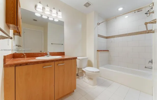 a bathroom with a sink a toilet a mirror a bathtub and shower