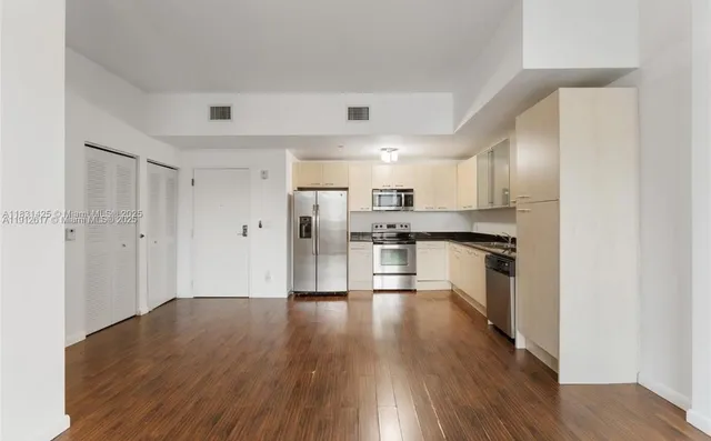 a large kitchen with stainless steel appliances a refrigerator and a stove top oven