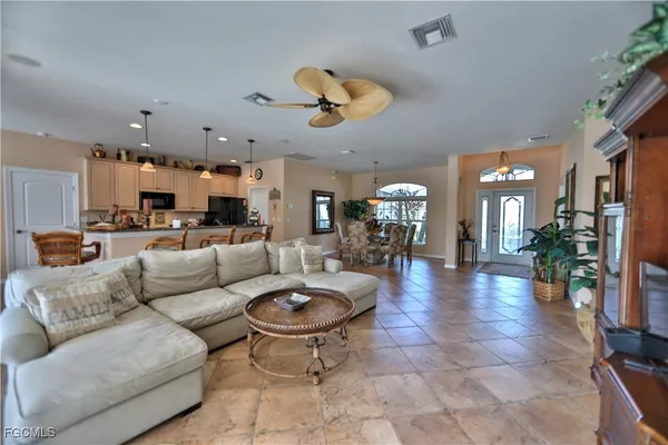 a living room with furniture kitchen view and a large window