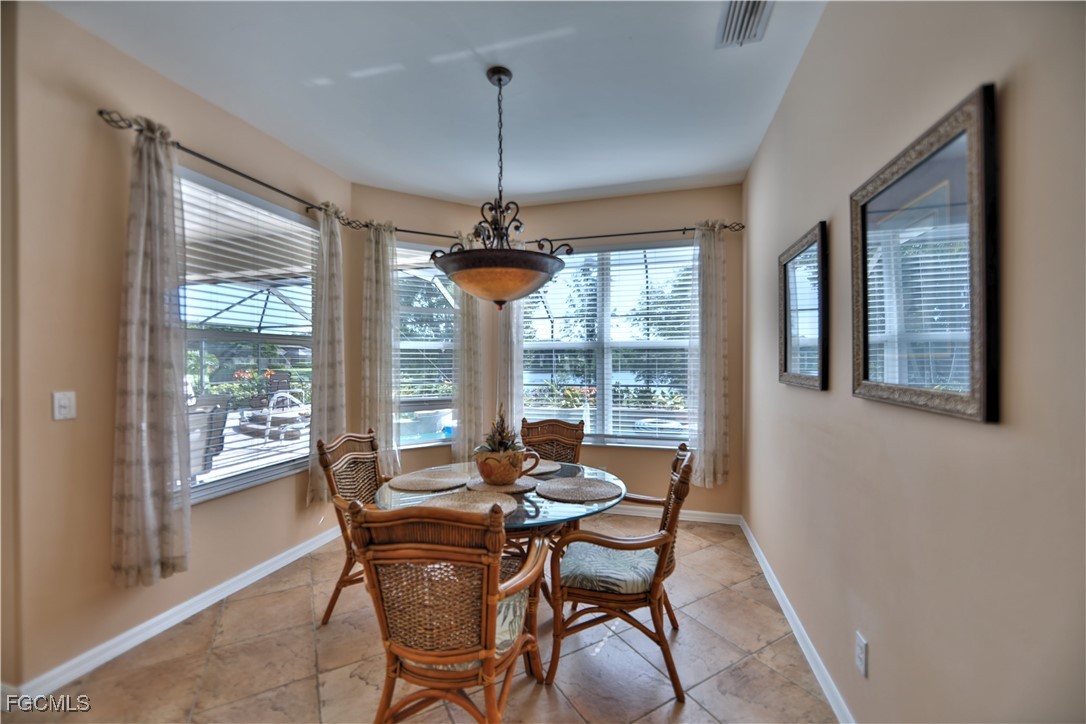 15022 Balmoral Loop Fort Myers, FL 33919 - Photo 23 of 27 a dining room with furniture a chandelier and wooden floor