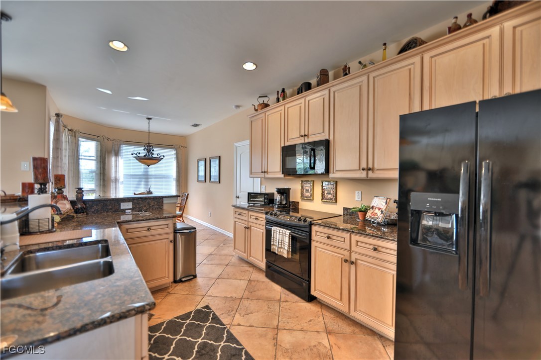 15022 Balmoral Loop Fort Myers, FL 33919 - Photo 25 of 27 a kitchen with stainless steel appliances granite countertop a refrigerator stove microwave and sink