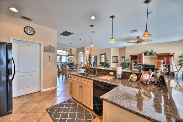 a kitchen with stainless steel appliances granite countertop a sink a stove and a refrigerator