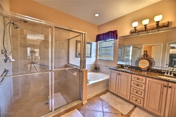 a spacious bathroom with a tub sink and mirror