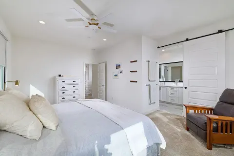 a bedroom with a bed a flat screen tv and dresser