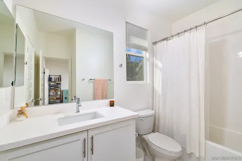 a bathroom with a sink a toilet a mirror and shower curtain