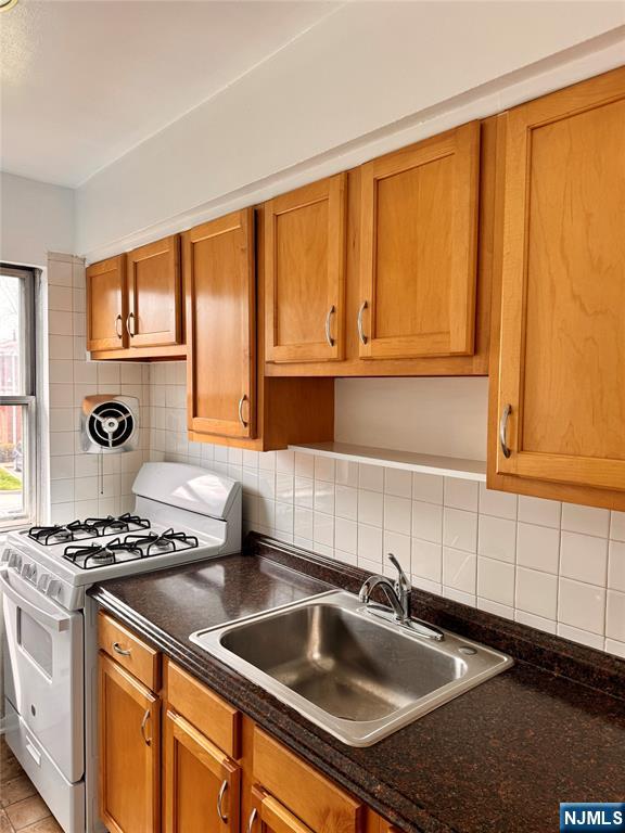 401 West Madison Avenue, Unit 7 Dumont, NJ 07628 - Photo 11 of 15 a kitchen with granite countertop a sink stove and cabinets