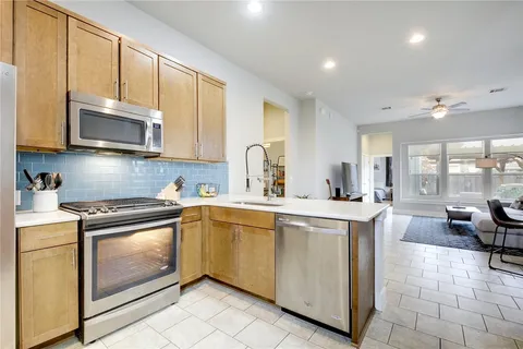a kitchen with stainless steel appliances granite countertop a stove a sink and a microwave
