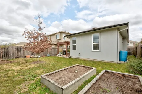 a view of a patio with table and chairs under an umbrella with a small yard