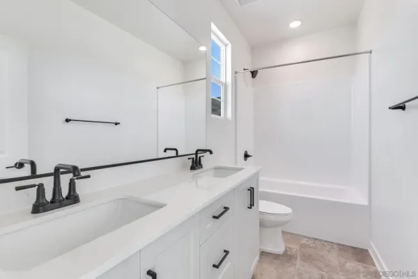 a bathroom with a tub a sink and a large mirror