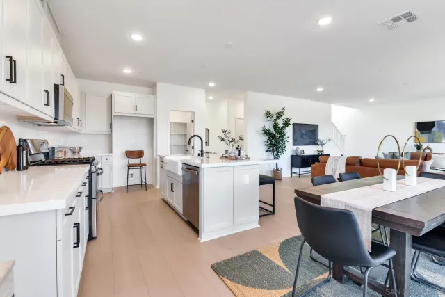 a kitchen with a sink white cabinets and stainless steel appliances