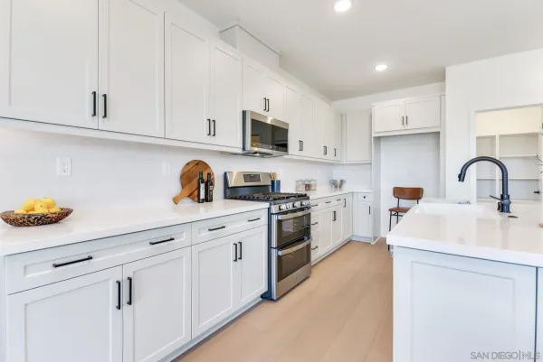 a kitchen with white cabinets and white appliances