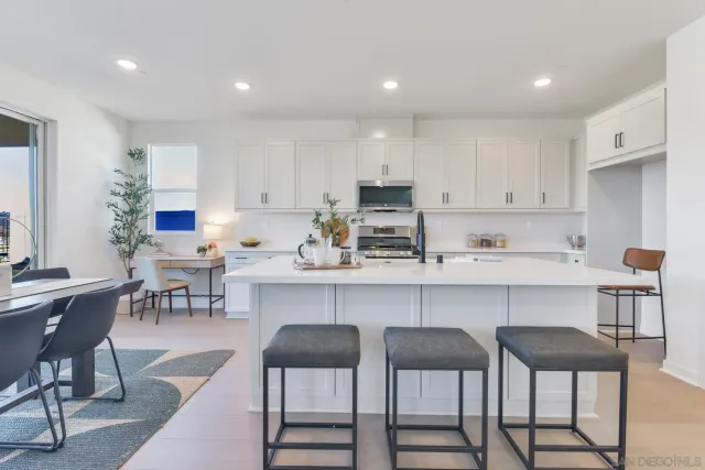 a kitchen with a dining table chairs and cabinets