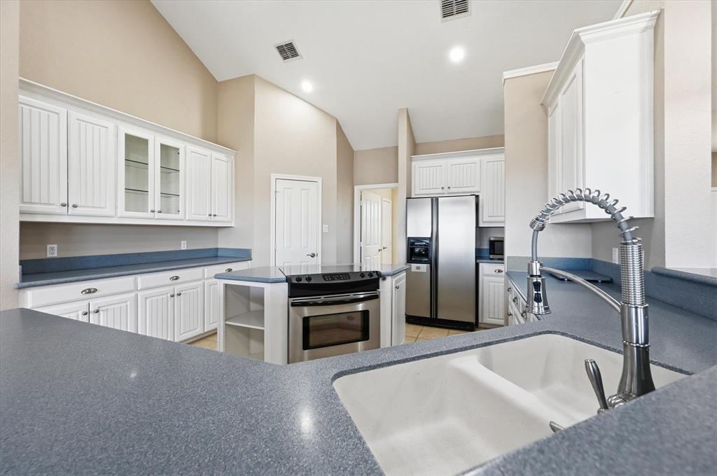 1616 Nash-Howard Road Waxahachie, TX 75165 - Photo 15 of 36 a kitchen with stainless steel appliances granite countertop a sink stove and refrigerator