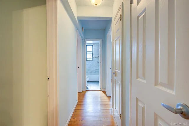 a view of a hallway with wooden floor and staircase