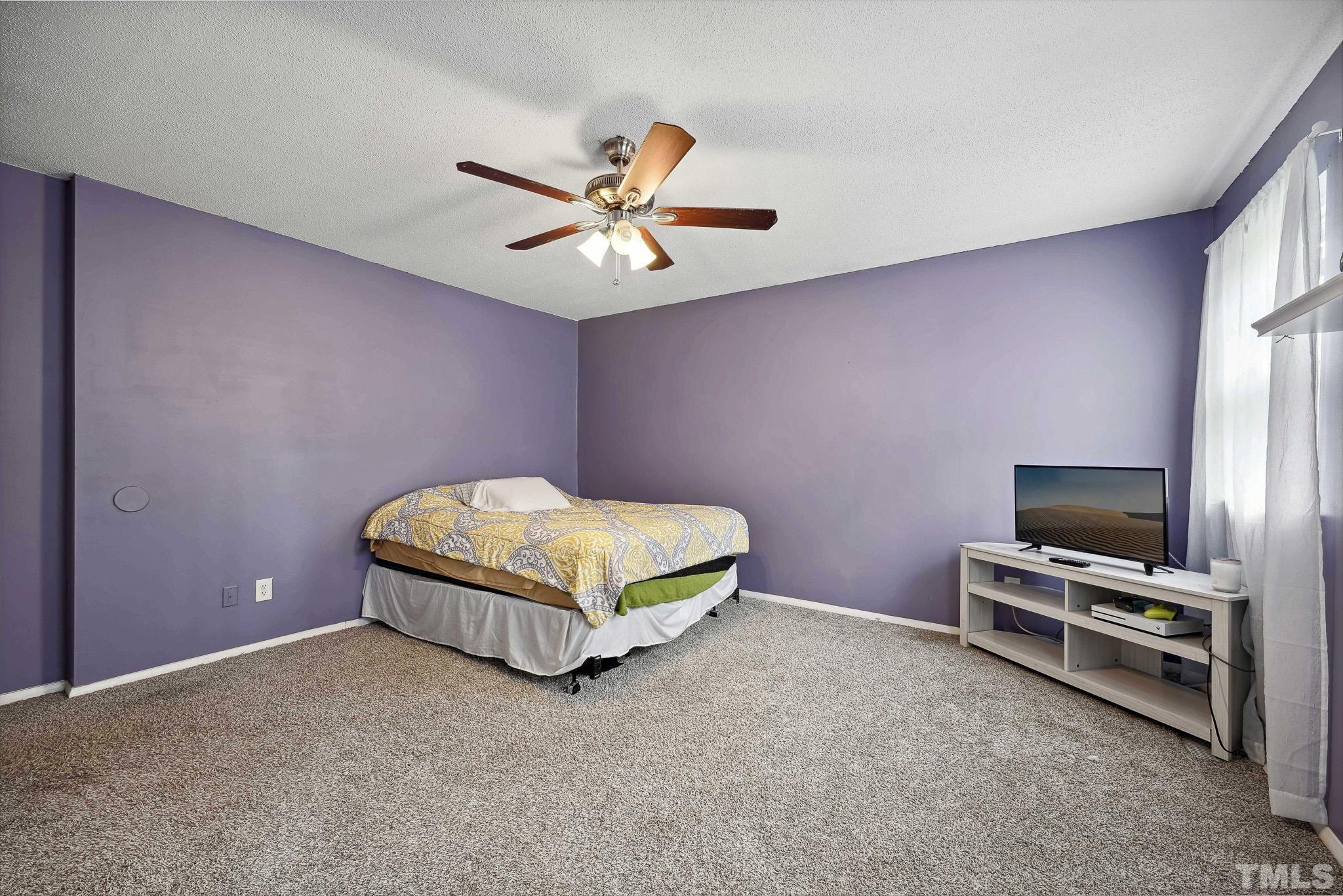 5809 Nottoway Court, Unit B Raleigh, NC 27609 - Photo 12 of 21 a bedroom with a bed and a flat screen tv