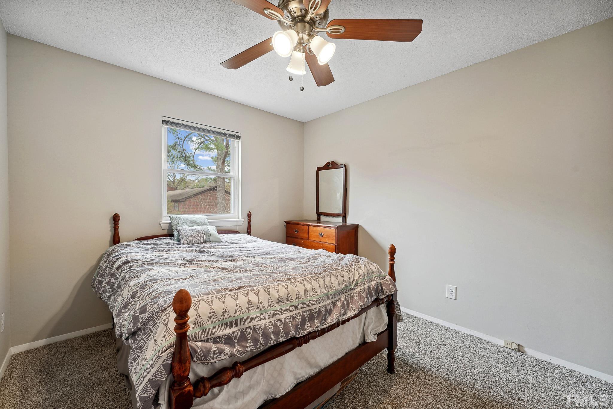 5809 Nottoway Court, Unit B Raleigh, NC 27609 - Photo 15 of 21 a bedroom with a bed and a chandelier