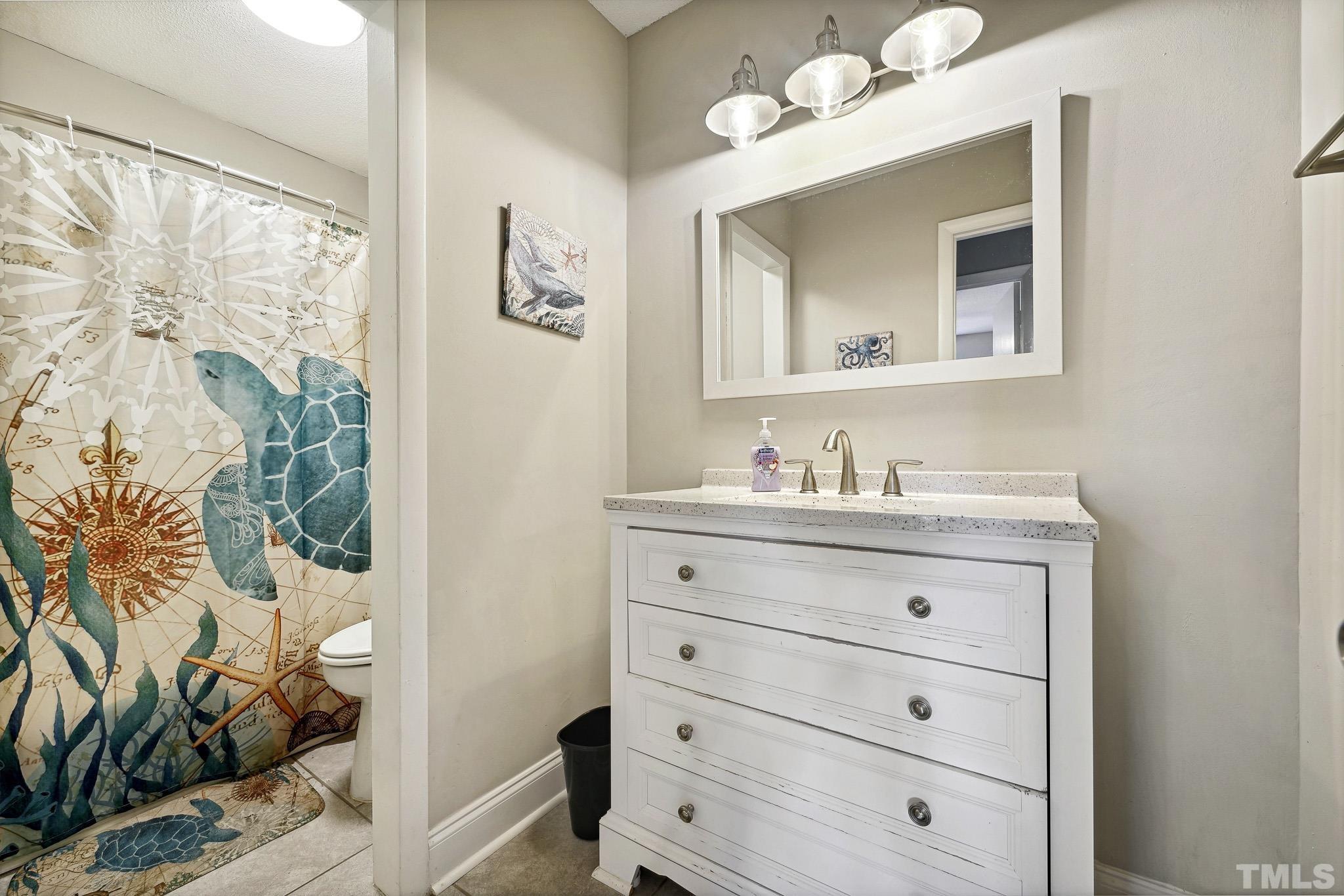 5809 Nottoway Court, Unit B Raleigh, NC 27609 - Photo 16 of 21 a bathroom with a granite countertop sink toilet and mirror
