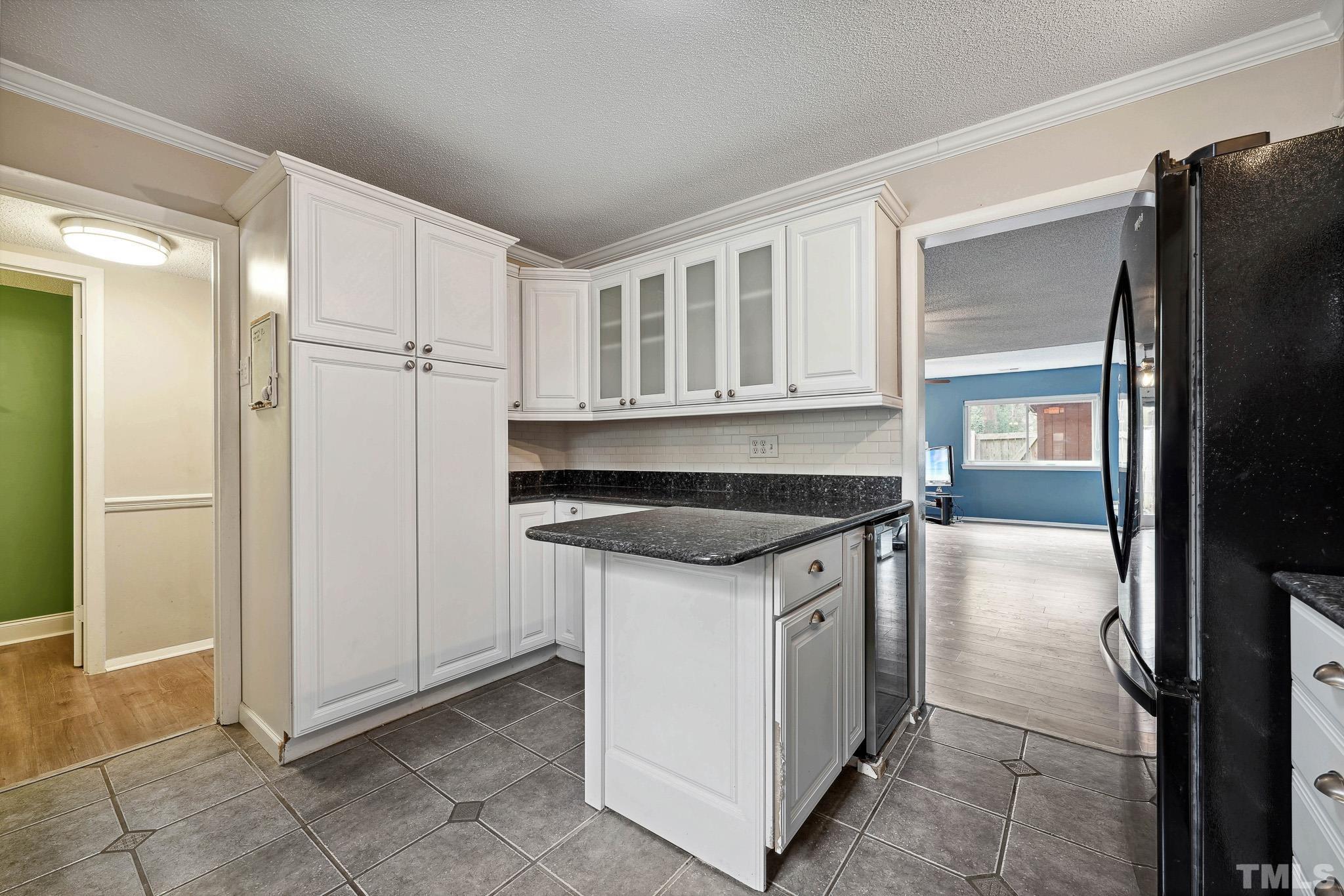 5809 Nottoway Court, Unit B Raleigh, NC 27609 - Photo 8 of 21 a kitchen with granite countertop a refrigerator and a stove top oven