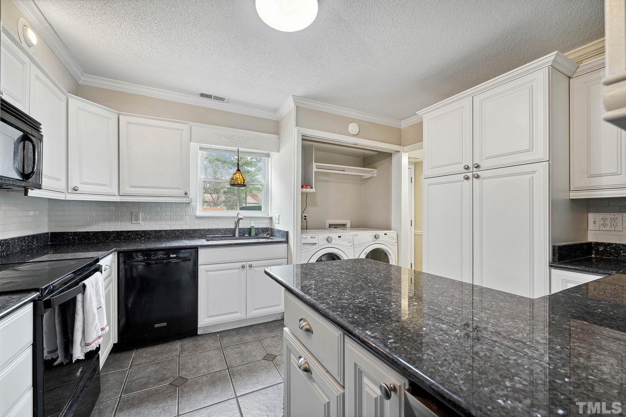 5809 Nottoway Court, Unit B Raleigh, NC 27609 - Photo 9 of 21 a kitchen with kitchen island granite countertop a stove a sink and a refrigerator
