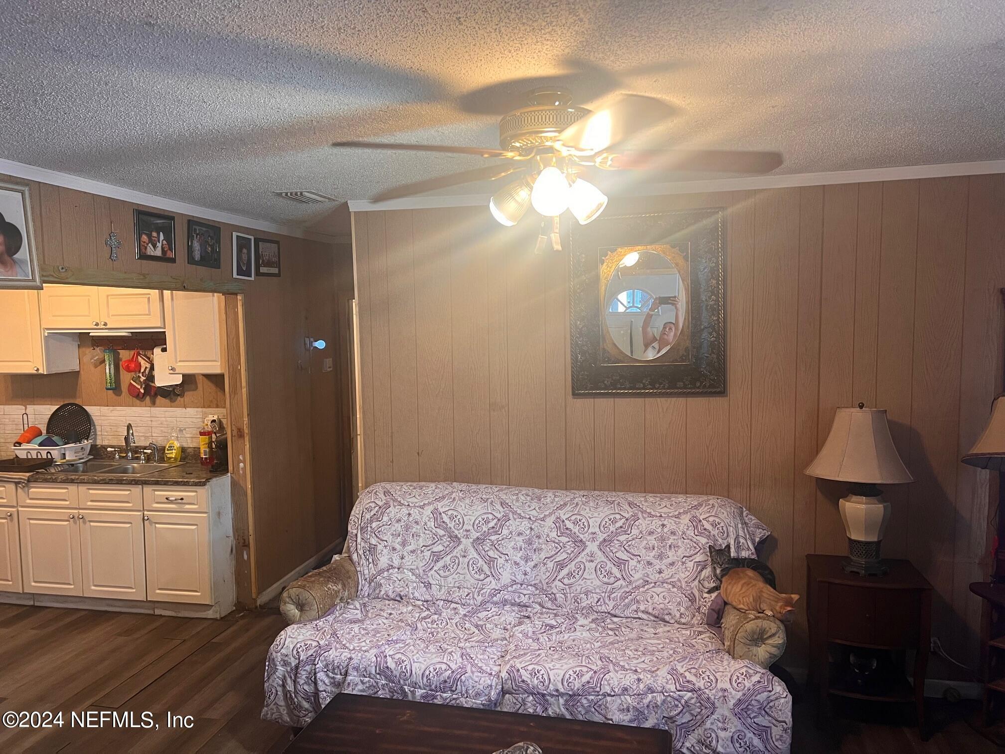 4203 Spring Park Road Jacksonville, FL 32207 - Photo 11 of 19 a bedroom with a large bed and a chandelier