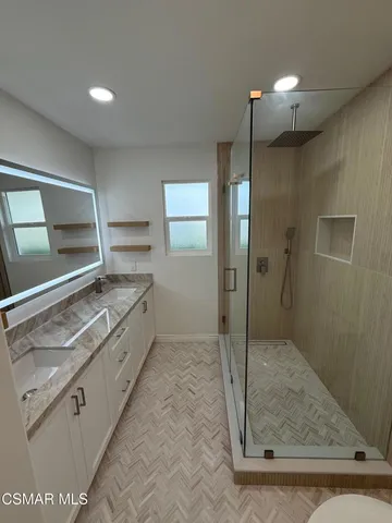 a bathroom with a double vanity sink and mirror