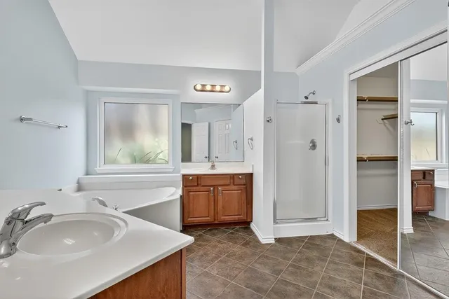 a spacious bathroom with a tub sink and mirror