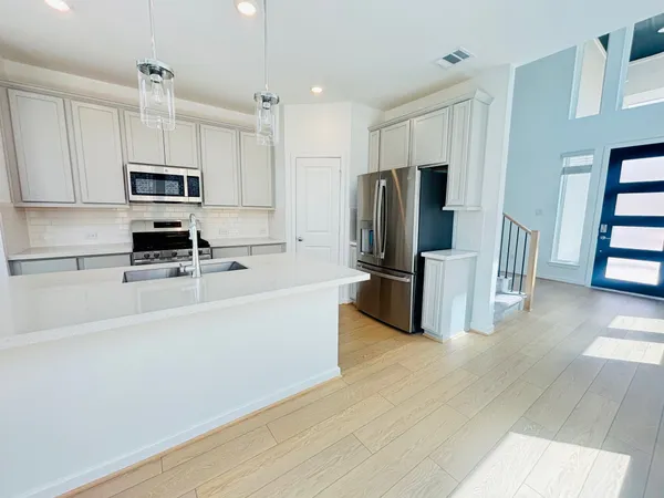 a kitchen with stainless steel appliances a refrigerator and a stove top oven