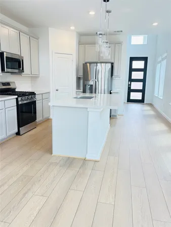 a large kitchen with cabinets and stainless steel appliances