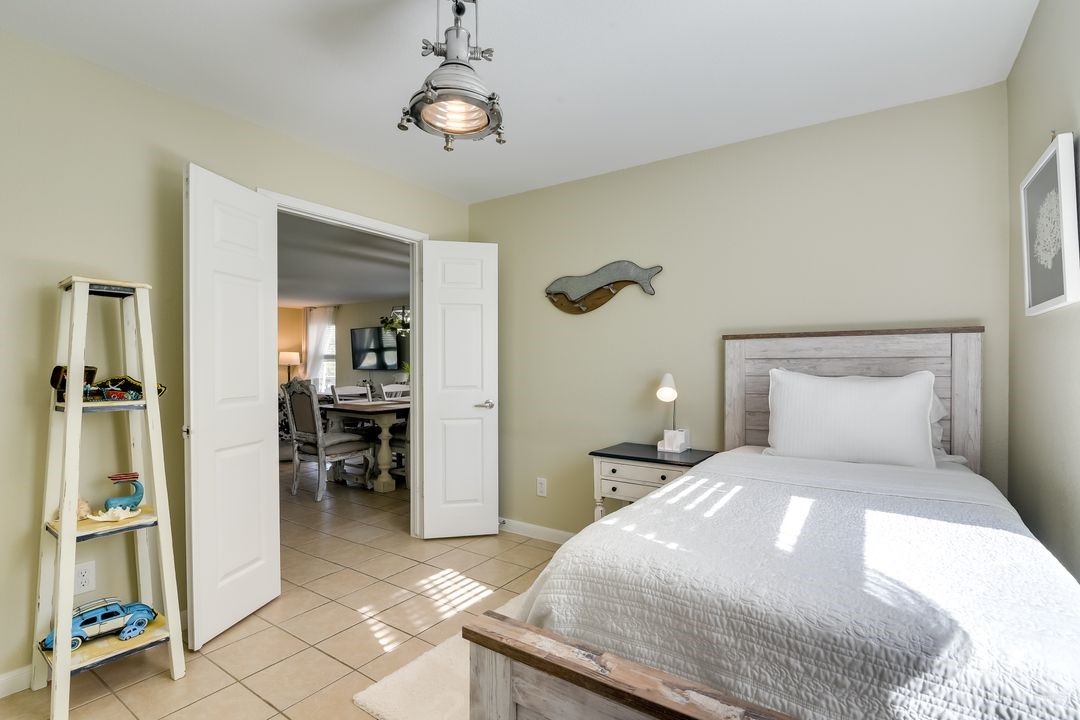 1206 4th Street Seabrook, TX 77586 - Photo 11 of 15 a bedroom with a large bed and a chandelier