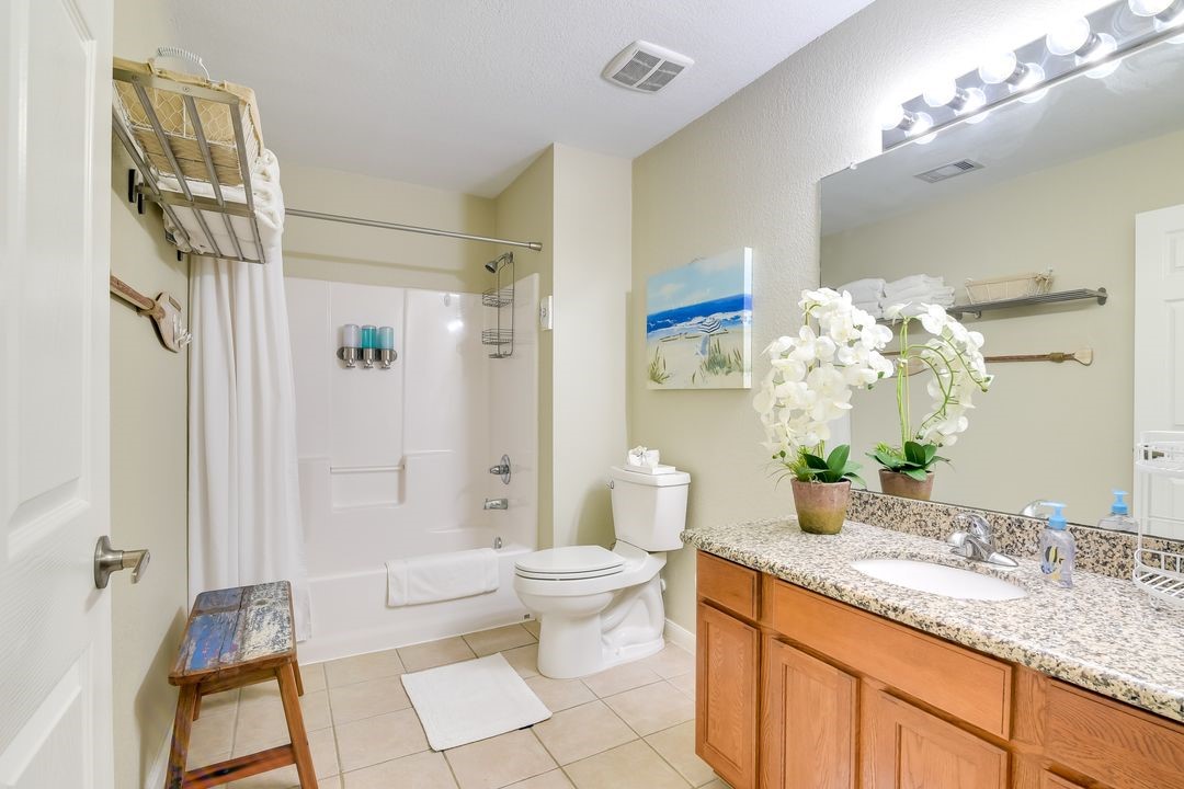1206 4th Street Seabrook, TX 77586 - Photo 13 of 15 a bathroom with a granite countertop sink a toilet and a mirror