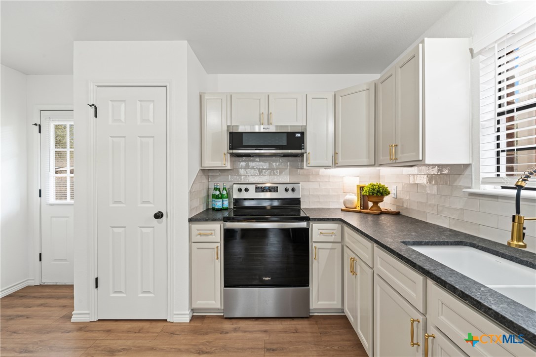 34 Golden Poppy Loop Belton, TX 76513 - Photo 11 of 27 a kitchen with stainless steel appliances granite countertop a stove a sink and a granite counter tops