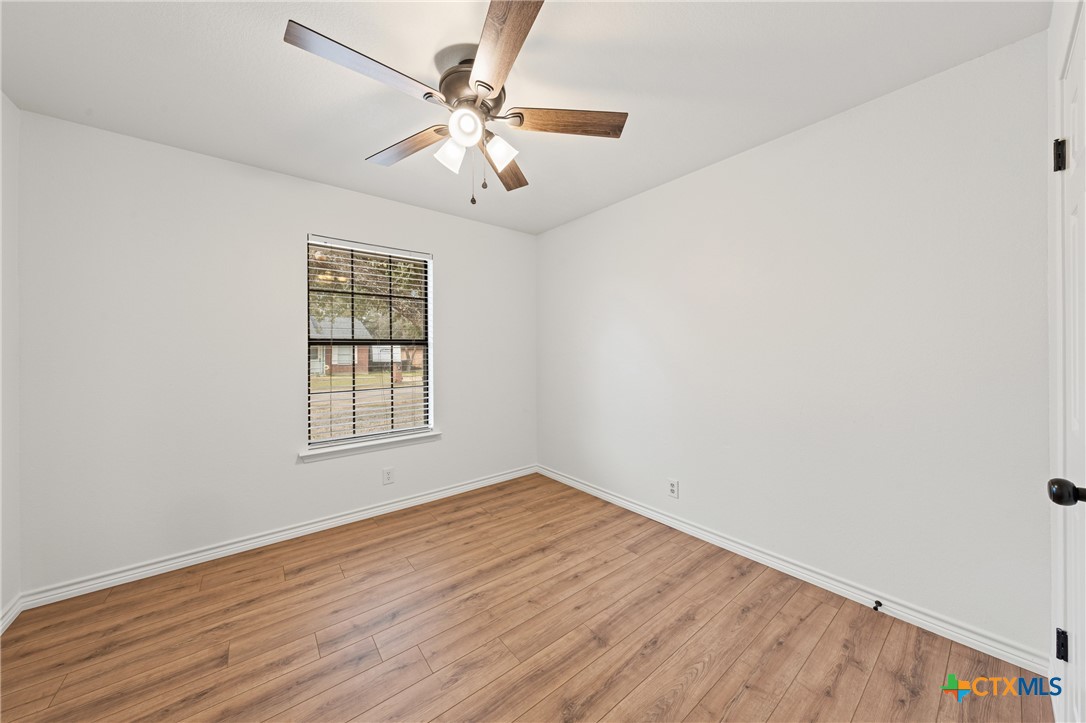 34 Golden Poppy Loop Belton, TX 76513 - Photo 16 of 27 an empty room with wooden floor chandelier fan and windows